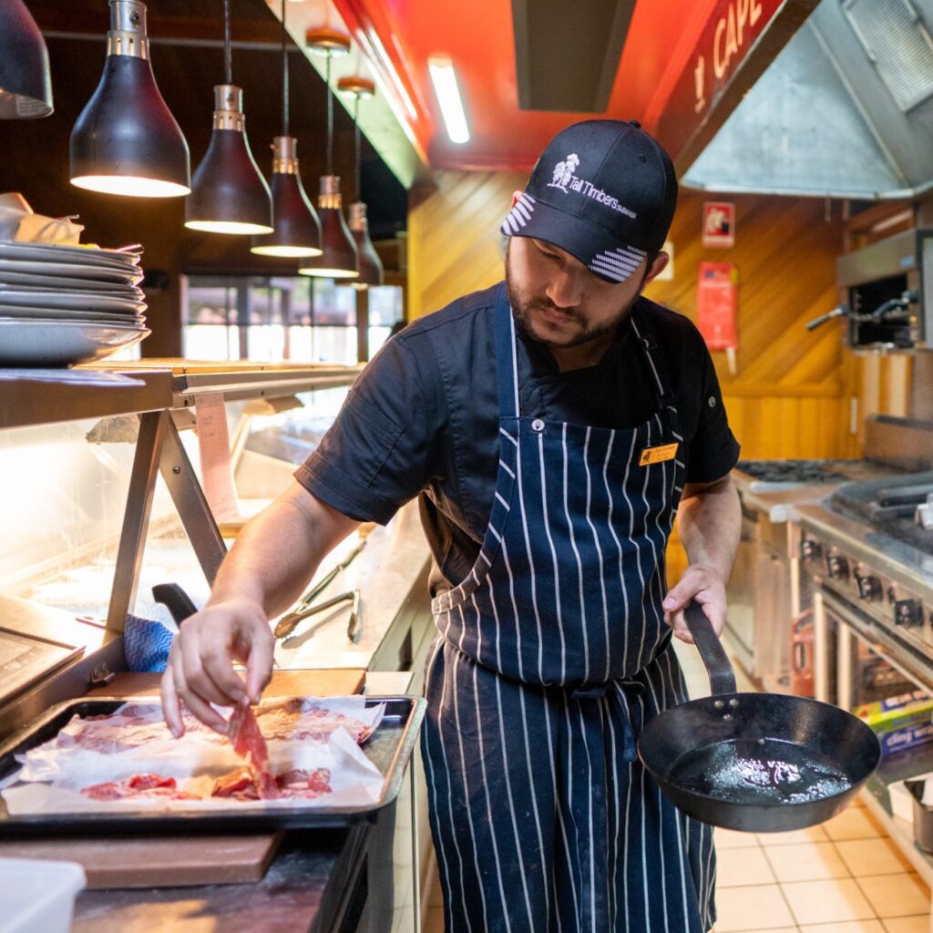 Chef picking up thinly cut Cape Grim beef to put into hot pan