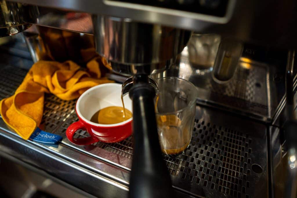 Coffee pouring into mug and glass