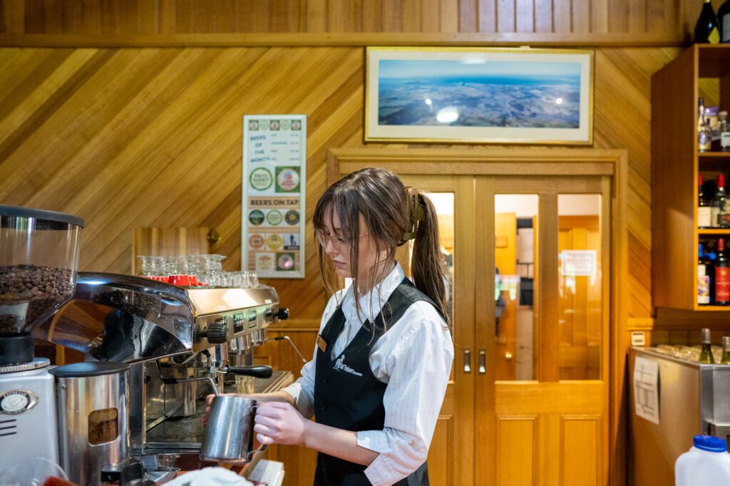 Aysha warming and frothing milk on coffee machine