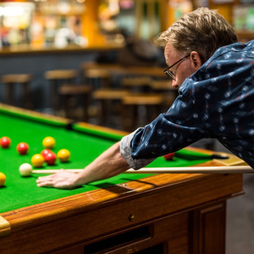 Man lining up shot at pool table in Millers Sports Bar