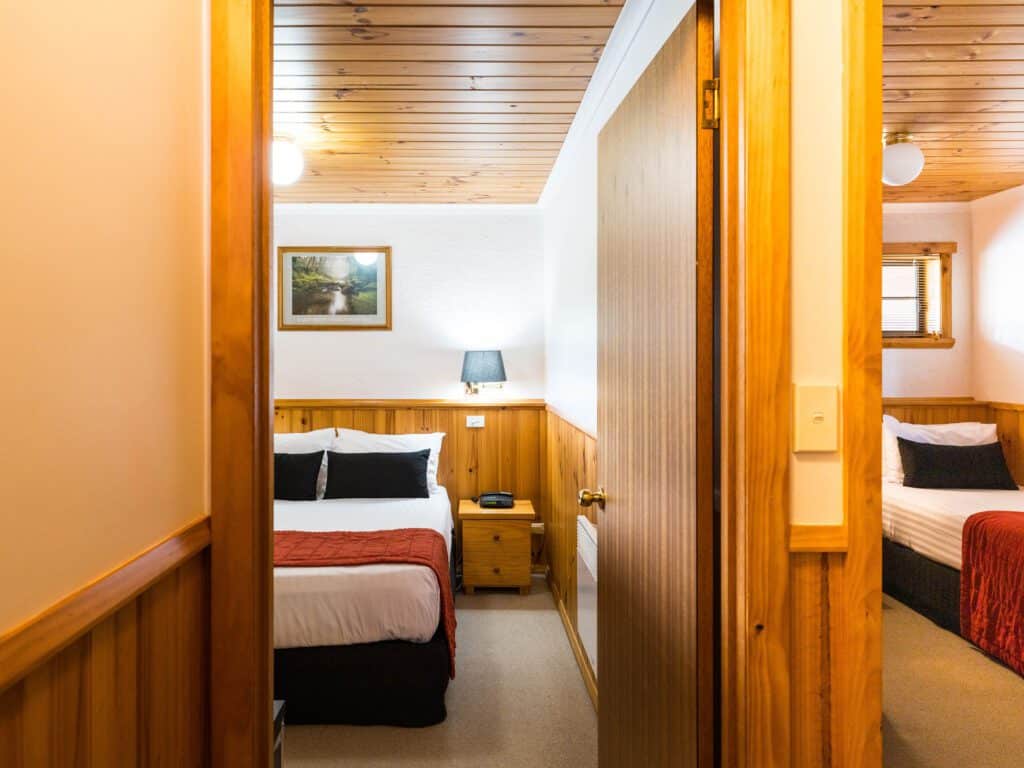 View from hallway into two bedrooms - one with queen bed and the other with 2 singles